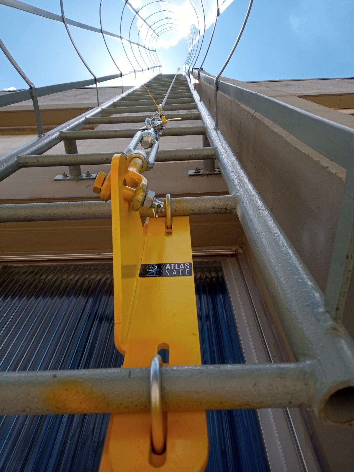 Linha de vida vertical instalada por dentro da gaiola de uma escada marinheiro